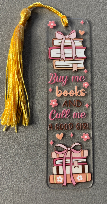 Decorative bookmark with books, tassel, and text saying buy me books and call me a good girl on a gray background