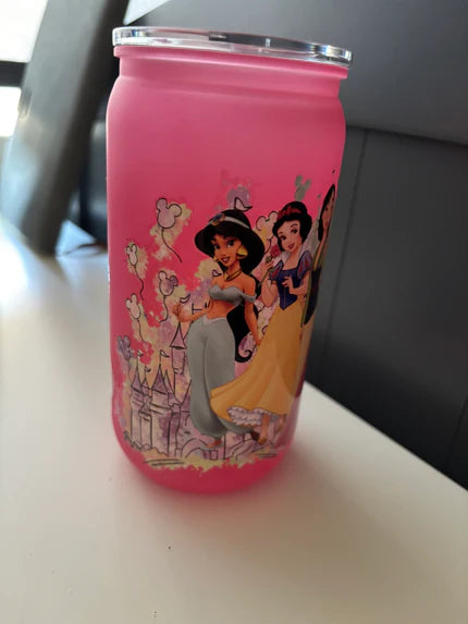 Pink tumbler with Disney princesses design on a white surface