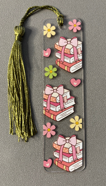 Decorative bookmark with tassel, books, flowers, and hearts on a gray background