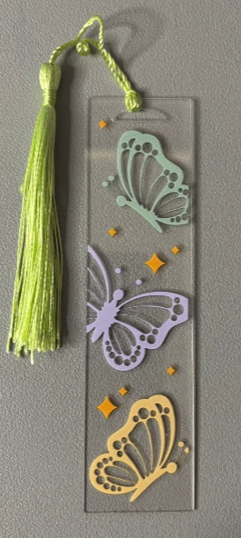 Decorative bookmark with butterfly designs and a tassel on a gray background