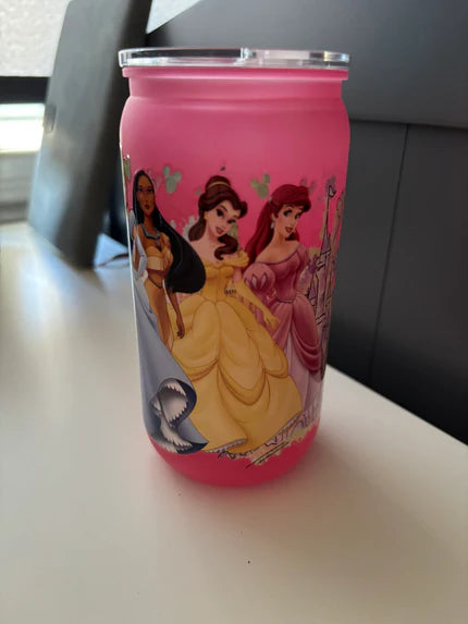 Pink tumbler with Disney princesses on a white surface