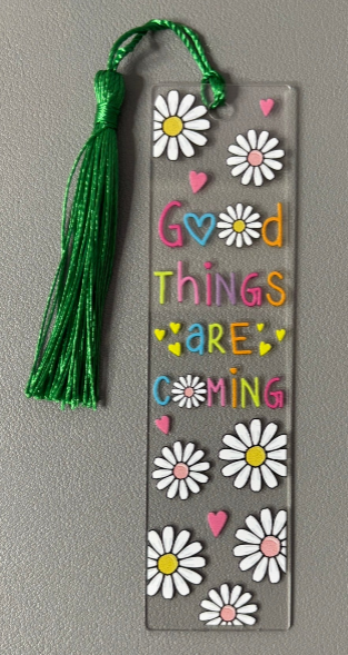 Decorative bookmark with flowers and text saying good things are coming on a gray background 