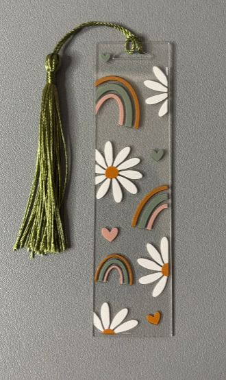 Decorative bookmark with flowers, rainbows, and a tassel on a gray background