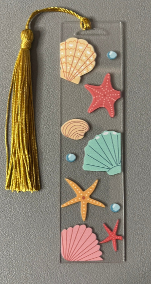 Bookmark with seashell and starfish designs on a gray background