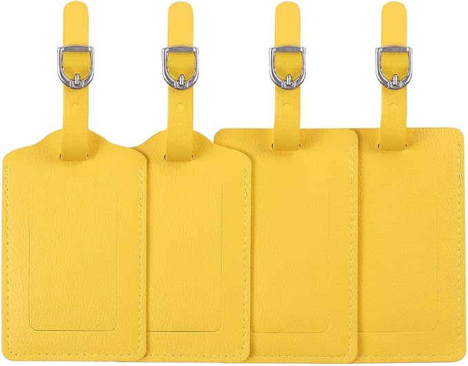 Four yellow luggage tags with silver clips on a white background