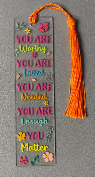 Decorative bookmark with motivational text and tassel on a gray background