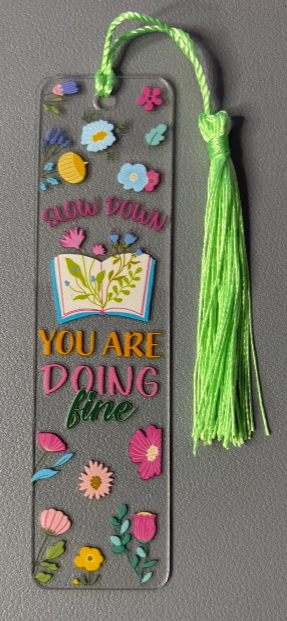 Decorative bookmark with colorful flowers and text saying slow down, you are doing fine on a gray background